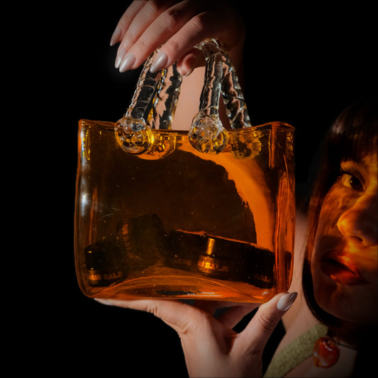 Model holding a transparent amber bag containing Magic Balm nasal balm jars